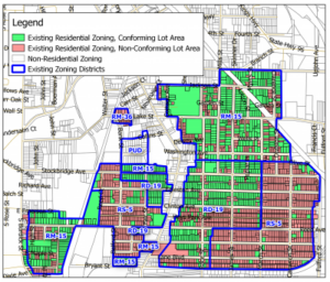 A GIS map showing neighborhood parcels in red and green, with zoning districts outlined in blue. Red non-conforming parcels completely saturate parts of the neighborhood.